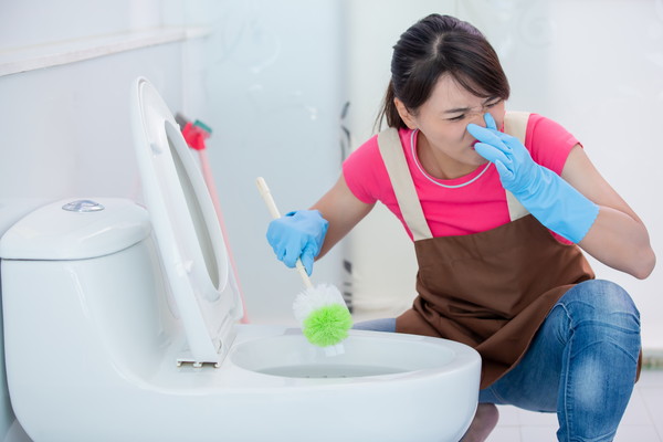 女性がトイレを磨く