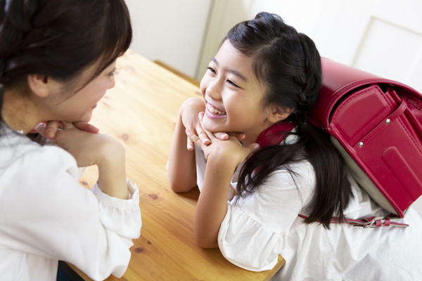 ランドセルを背負う女の子と母