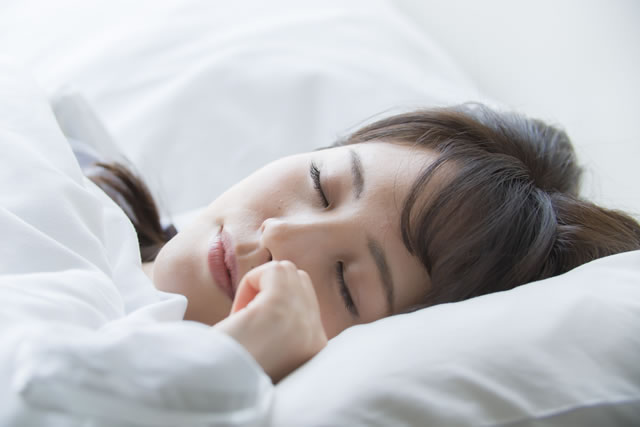 布団で寝る女性